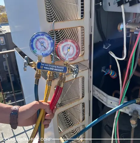Technician using HVAC gauges to check airconditioningsustem pressure.